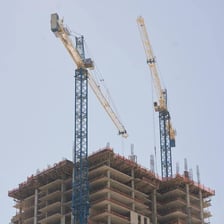 A tower crane lifting materials above a construction site.