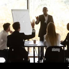 A person raising a hand to take a turn speaking in a meeting.