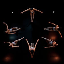 A group of dancers performing the same movement in synchronization