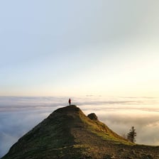 A mountain summit rising above the surrounding landscape.