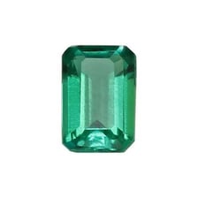 A green faceted emerald gemstone
