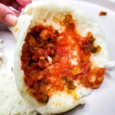 Colombian arepas served with tomato-and-onion hogao sauce.