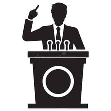 A speaker delivering a speech from a podium.