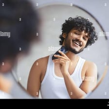 A person checking and arranging their appearance in a mirror.
