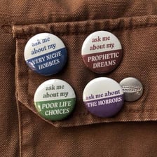 A museum docent wearing a badge that says “Ask Me.”