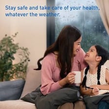 A person indoors while rain falls outside