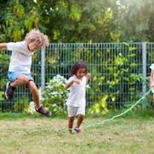 A child moving with a joyful skipping step outdoors.