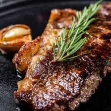 A fully cooked steak served on a plate.