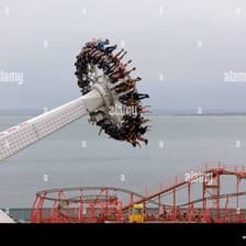 An inverted roller coaster train carrying riders below the track.