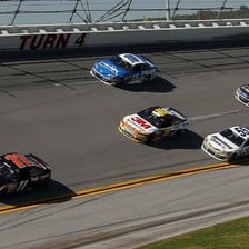 A NASCAR stock car racing around a track