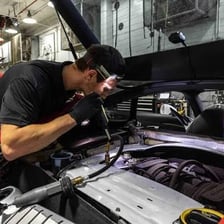 A mechanic servicing a car in an auto repair garage.