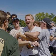 College fraternity members standing together outdoors.