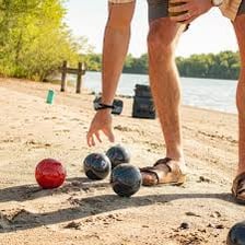 Players rolling bocce balls toward a small target ball