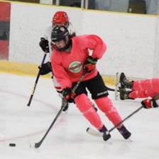 A hockey player fastening a skate before entering the rink.