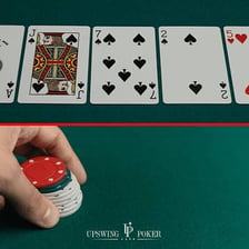 Players gathered around a poker table with cards and chips.