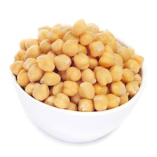 Dried chickpeas beside green legume pods.
