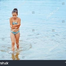 A person wrapped in a towel and visibly shivering after cold-water swimming.