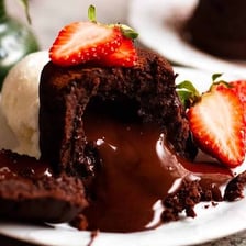 A chocolate lava cake cut open to reveal its flowing center.