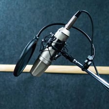A voice actor records dubbed dialogue in a studio.