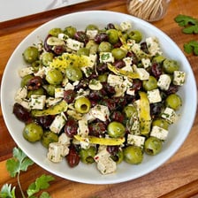 A Greek salad containing black and green olives, feta, and vegetables.