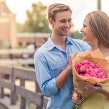 Two people smile at each other across a table.