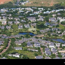 An aerial view of open green space bordering an urban area.