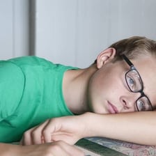 A person sitting idly and appearing bored or listless