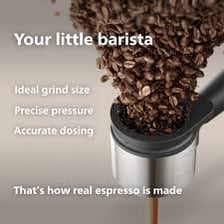 A barista grinding coffee beans beside an espresso machine