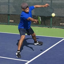 A pickleball player striking the ball with a forehand swing.