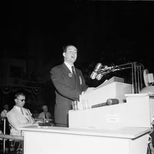 A politician delivering a speech from a podium at a convention.