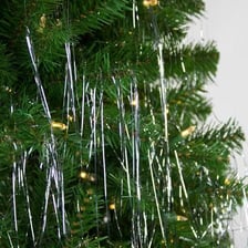 Shiny strands of tinsel draped over a decorated Christmas tree