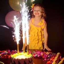 Bright sparklers are being held at a birthday celebration.