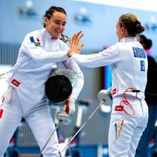 An athlete holding an épée during a fencing bout