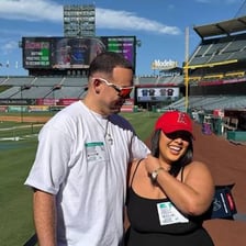 A couple appearing on a kiss-cam screen at a baseball stadium.