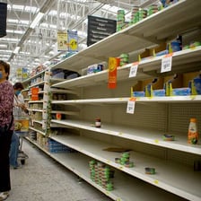 Store shelves with visible gaps caused by a supply shortage.