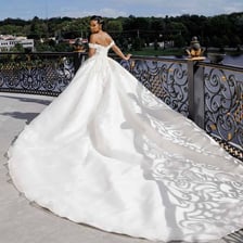 A wedding dress with fabric extending behind the bride