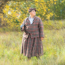 A person in traditional Scottish clothing in a Highland landscape.