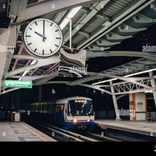 A train arriving at a station with a clock visible