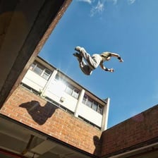 A parkour athlete leaping between urban obstacles.