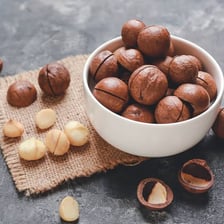 Macadamia nuts shown in their shells and as shelled kernels.