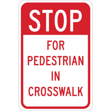 A red stop sign beside a pedestrian crosswalk