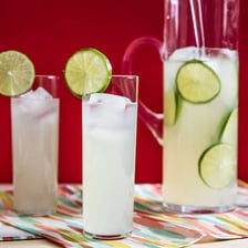 Glasses of pale citrus drinks garnished with lemon and lime
