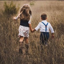 A brother standing with his sisters