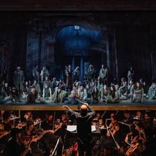 An opera singer performing with an orchestra.