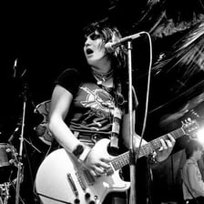 Joan Jett performing onstage with a microphone.