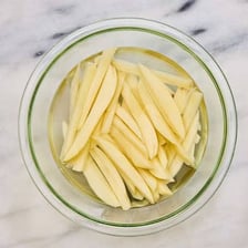Whole potatoes beside cut potatoes intended for French fries
