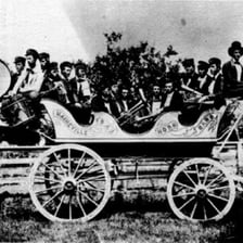 A decorated wagon carrying a musical band in a parade