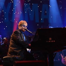 Elton John performing at a piano