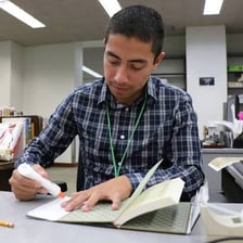 An office clerk working at a desk with paperwork.