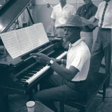 A portrait of Nat King Cole performing.